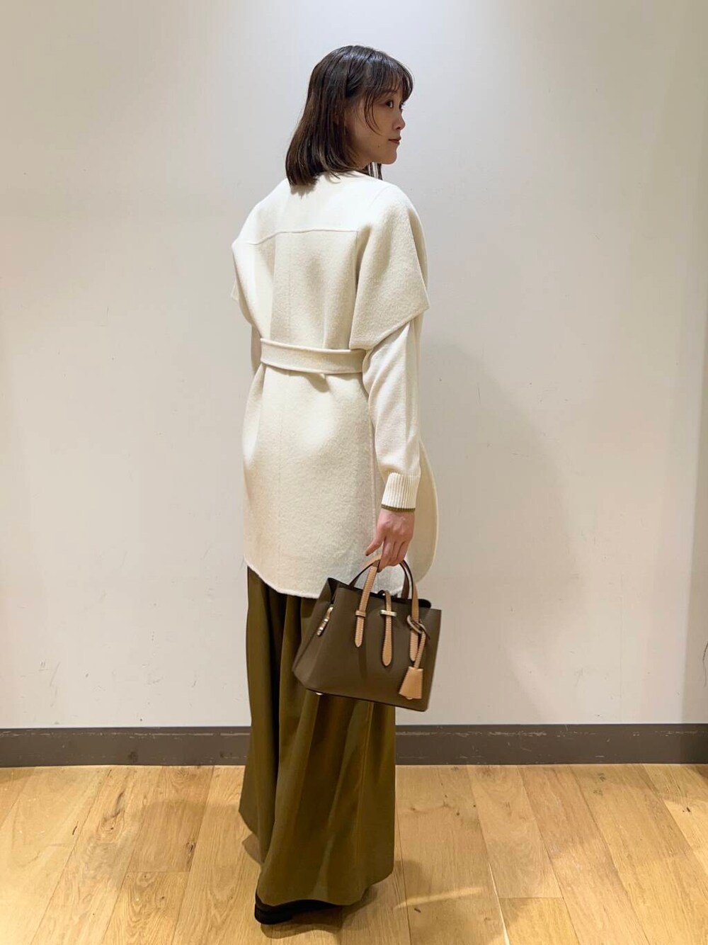 ブラック系のローファー、ブラウン系のハンドバッグ、ベージュ系のその他パンツを着用したレディースの冬コーディネートの4枚目の写真