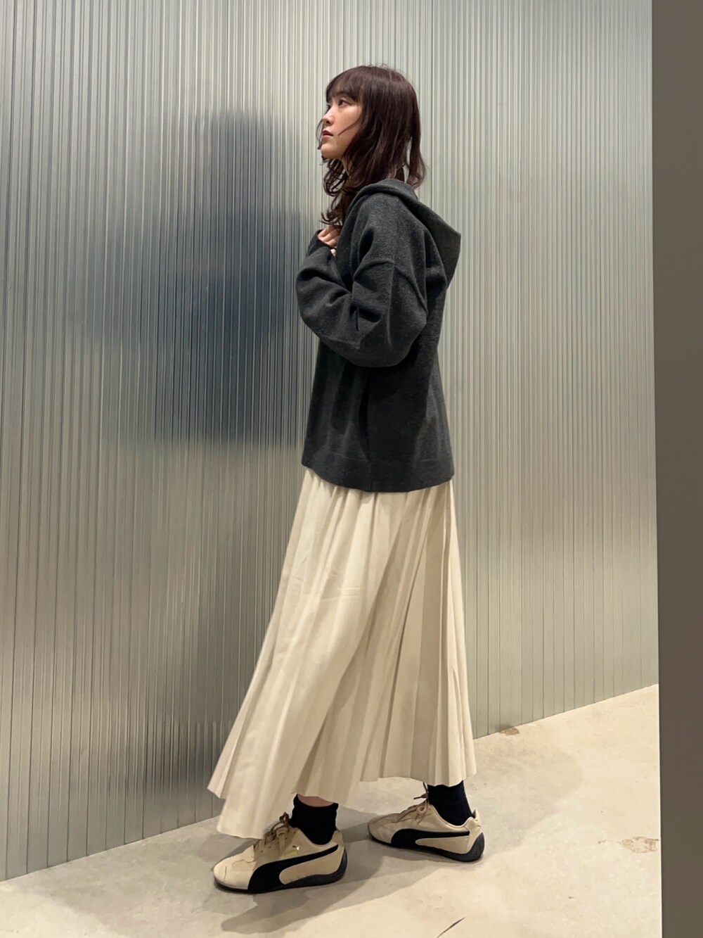 グレー系のニット/セーター、イエロー系のTシャツ/カットソー、ブラック系のダウンジャケット/コートを着用したレディースの冬コーディネートの4枚目の写真