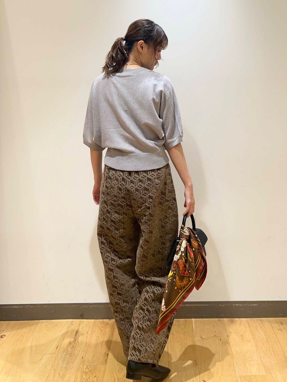 ブラック系のショルダーバッグ、ブラウン系のその他パンツ、グレー系のニット/セーターを着用したレディースの秋コーディネートの3枚目の写真