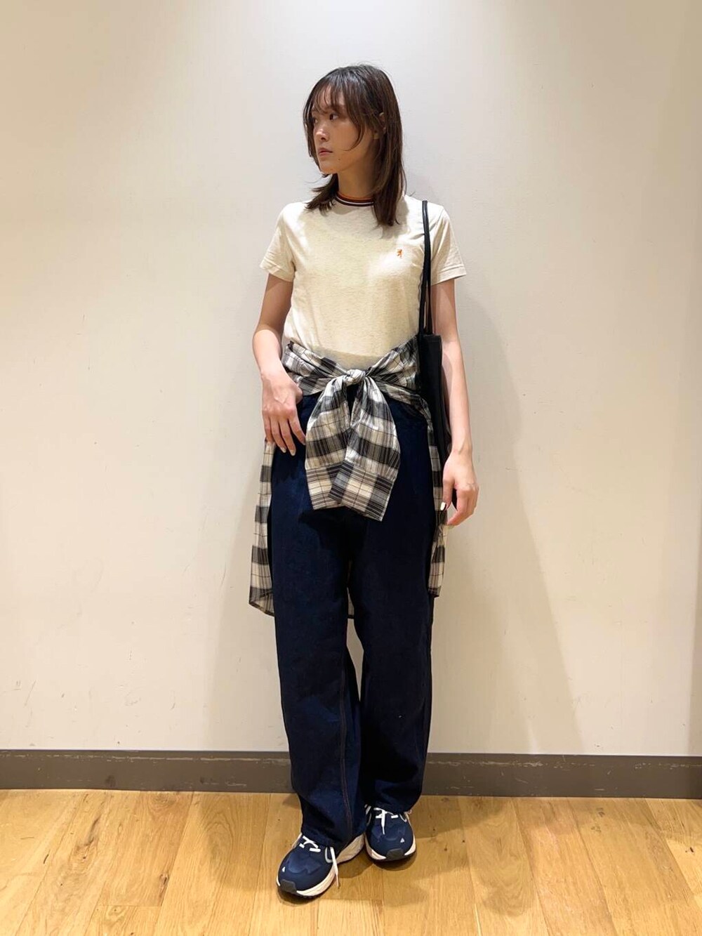 ブルー系のスニーカー、ブラック系のトートバッグ、ブラック系のシャツ/ブラウスを着用したレディースの春コーディネートの2枚目の写真