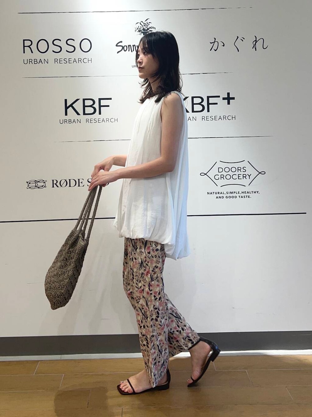 グレー系のトートバッグ、ピンク系のその他パンツ、ブラウン系のサンダルを着用したレディースの夏コーディネートの2枚目の写真