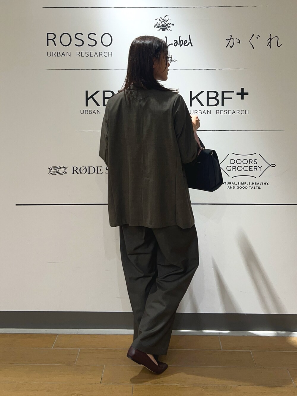 ピンク系のシャツ/ブラウス、ブラウン系のその他アウター、ブルー系のハンドバッグを着用したレディースの秋コーディネートの4枚目の写真