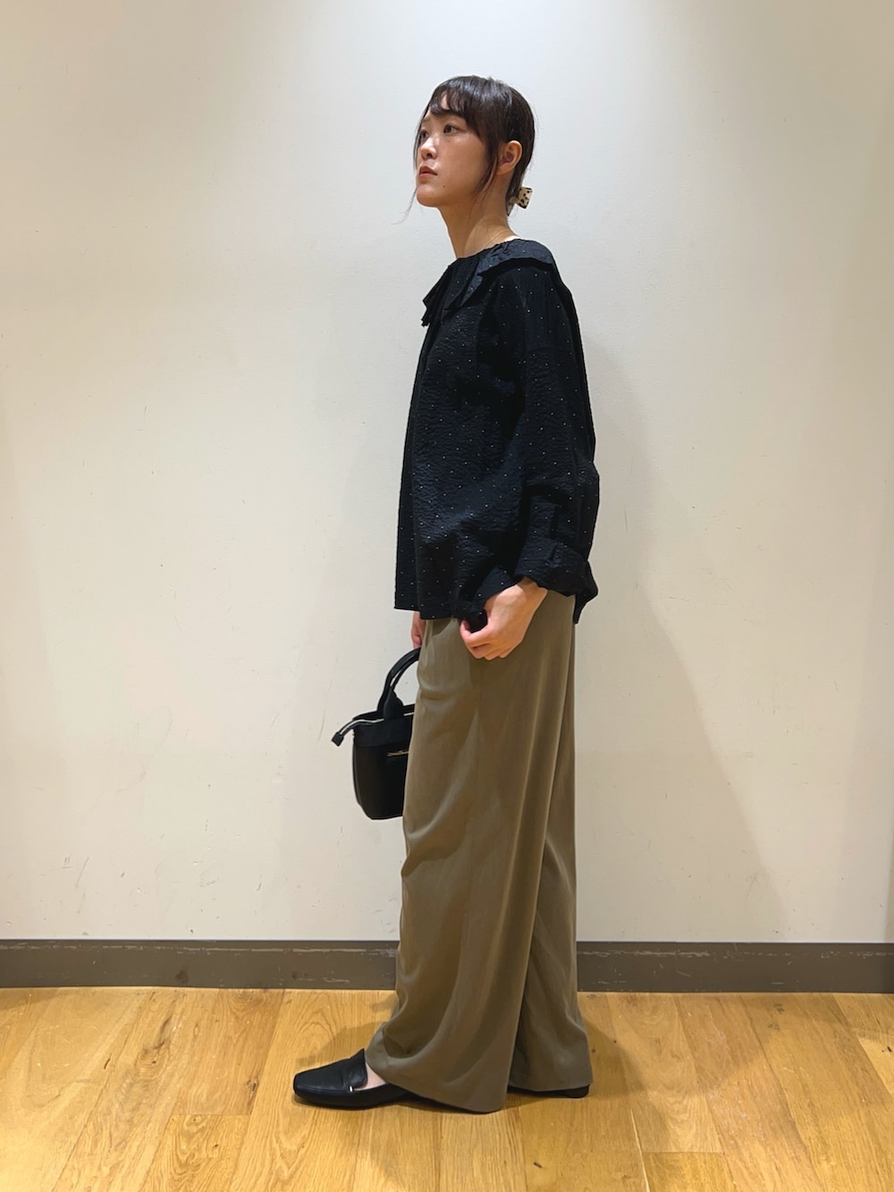 ブラック系のシャツ/ブラウス、グリーン系のその他パンツ、ブラック系のハンドバッグを着用したレディースの秋コーディネートの3枚目の写真