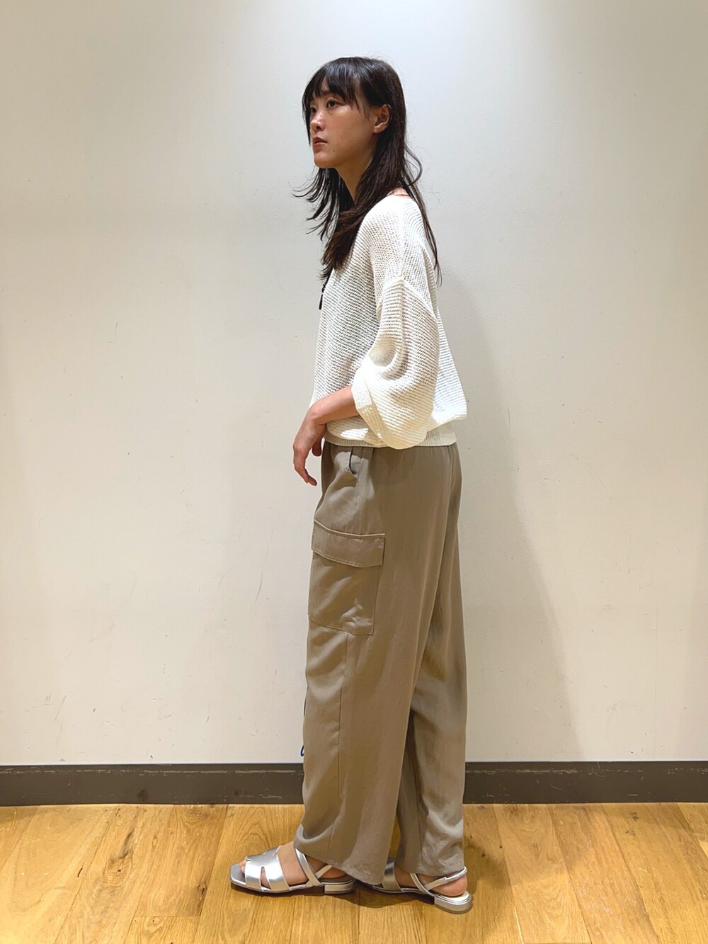 ホワイト系のニット/セーター、ベージュ系のその他パンツ、シルバー系のサンダルを着用したレディースの春コーディネートの2枚目の写真