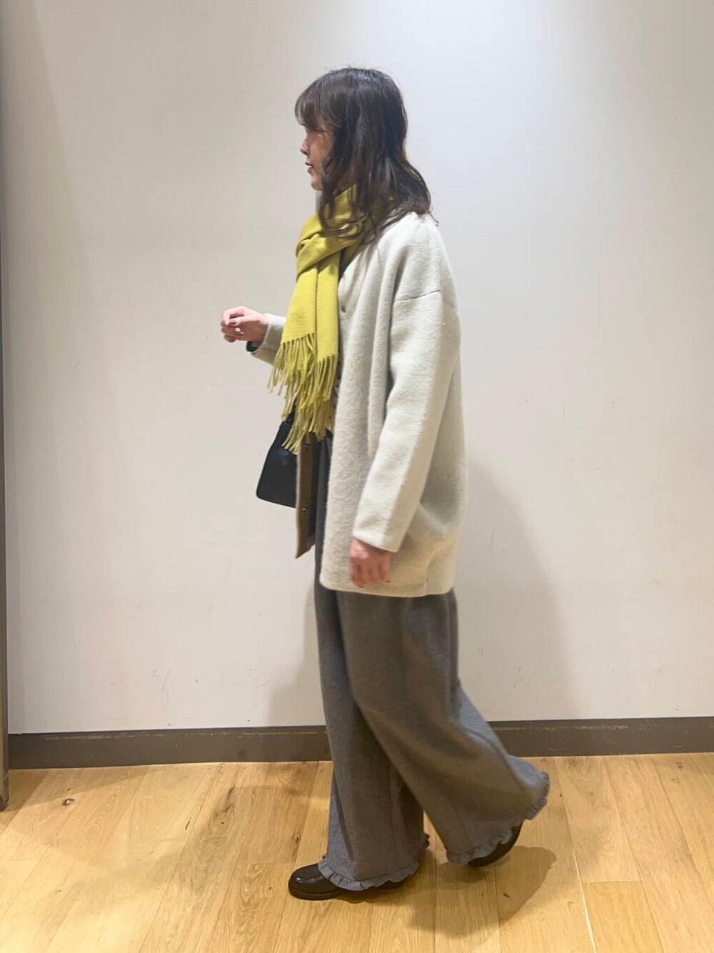 グレー系のその他パンツ、ホワイト系のニット/セーター、ブラック系のハンドバッグを着用したレディースの秋コーディネートの5枚目の写真