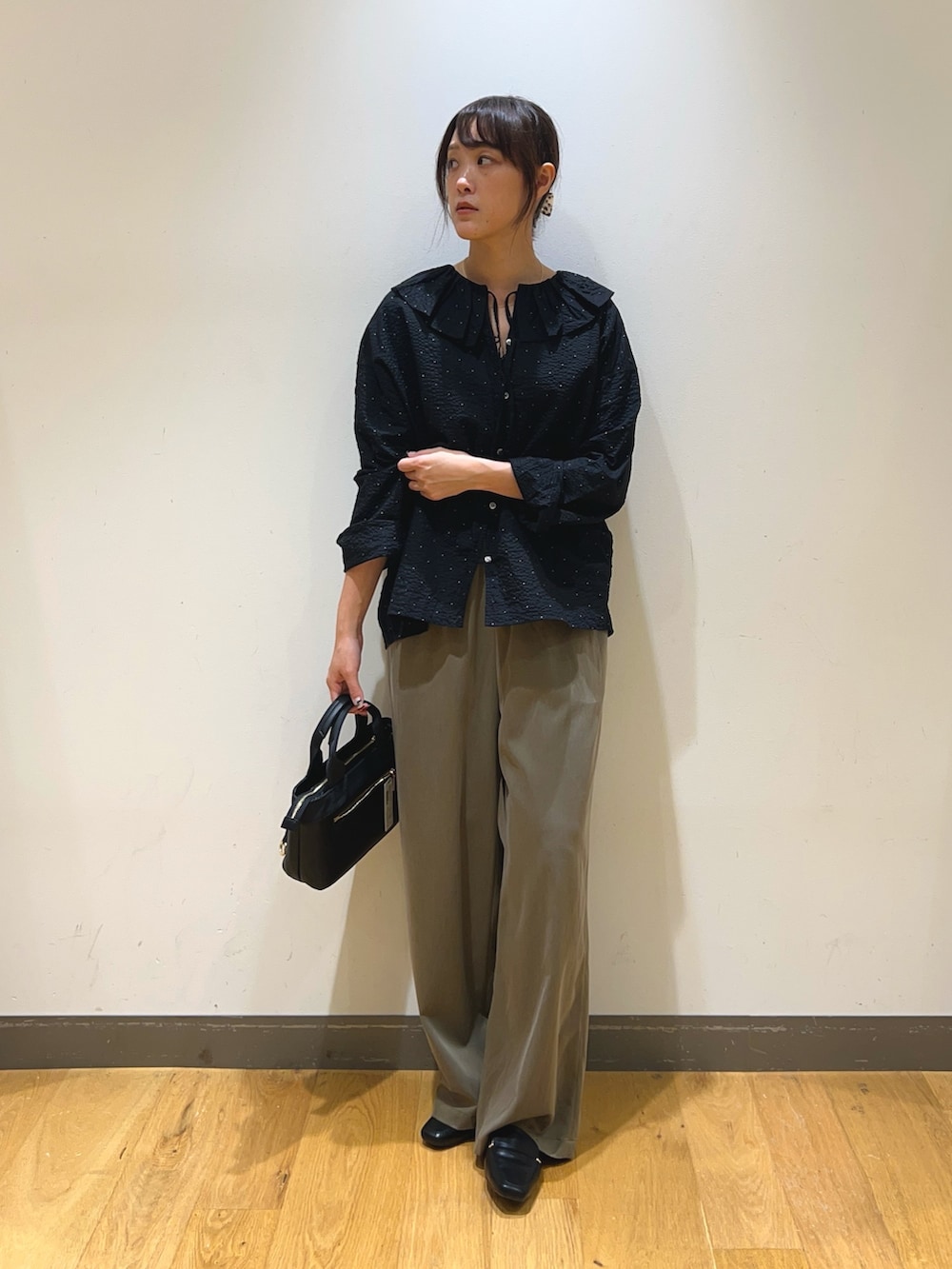 ブラック系のシャツ/ブラウス、グリーン系のその他パンツ、ブラック系のハンドバッグを着用したレディースの秋コーディネートの2枚目の写真