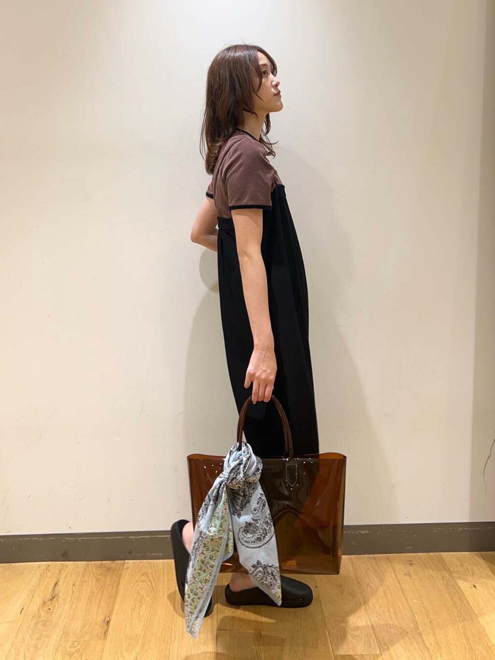 ブラック系のサロペット/オーバーオール、ブラウン系のトートバッグ、ブラック系のサンダルを着用したレディースの春コーディネートの2枚目の写真