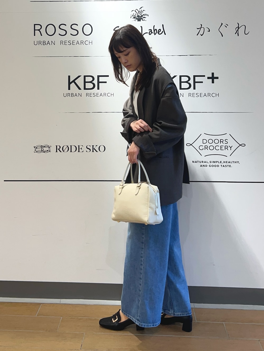 ホワイト系のニット/セーター、ブラウン系のその他アウター、ブルー系のデニムパンツを着用したレディースの冬コーディネートの2枚目の写真