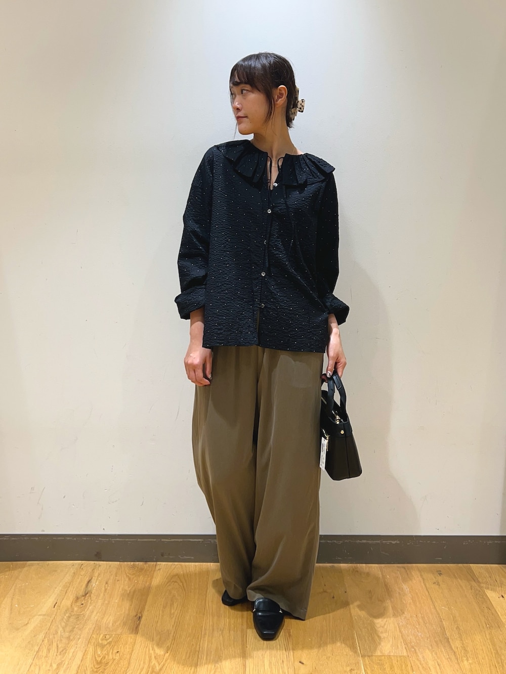 ブラック系のシャツ/ブラウス、グリーン系のその他パンツ、ブラック系のハンドバッグを着用したレディースの秋コーディネートの4枚目の写真
