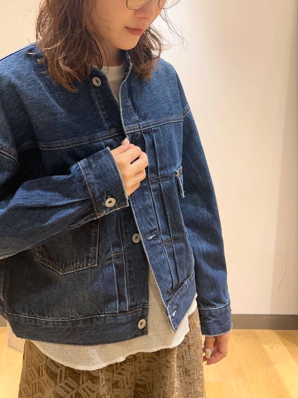 ブラウン系のブーツ、ホワイト系のTシャツ/カットソー、ブルー系のデニムジャケットを着用したレディースの秋コーディネートの3枚目の写真