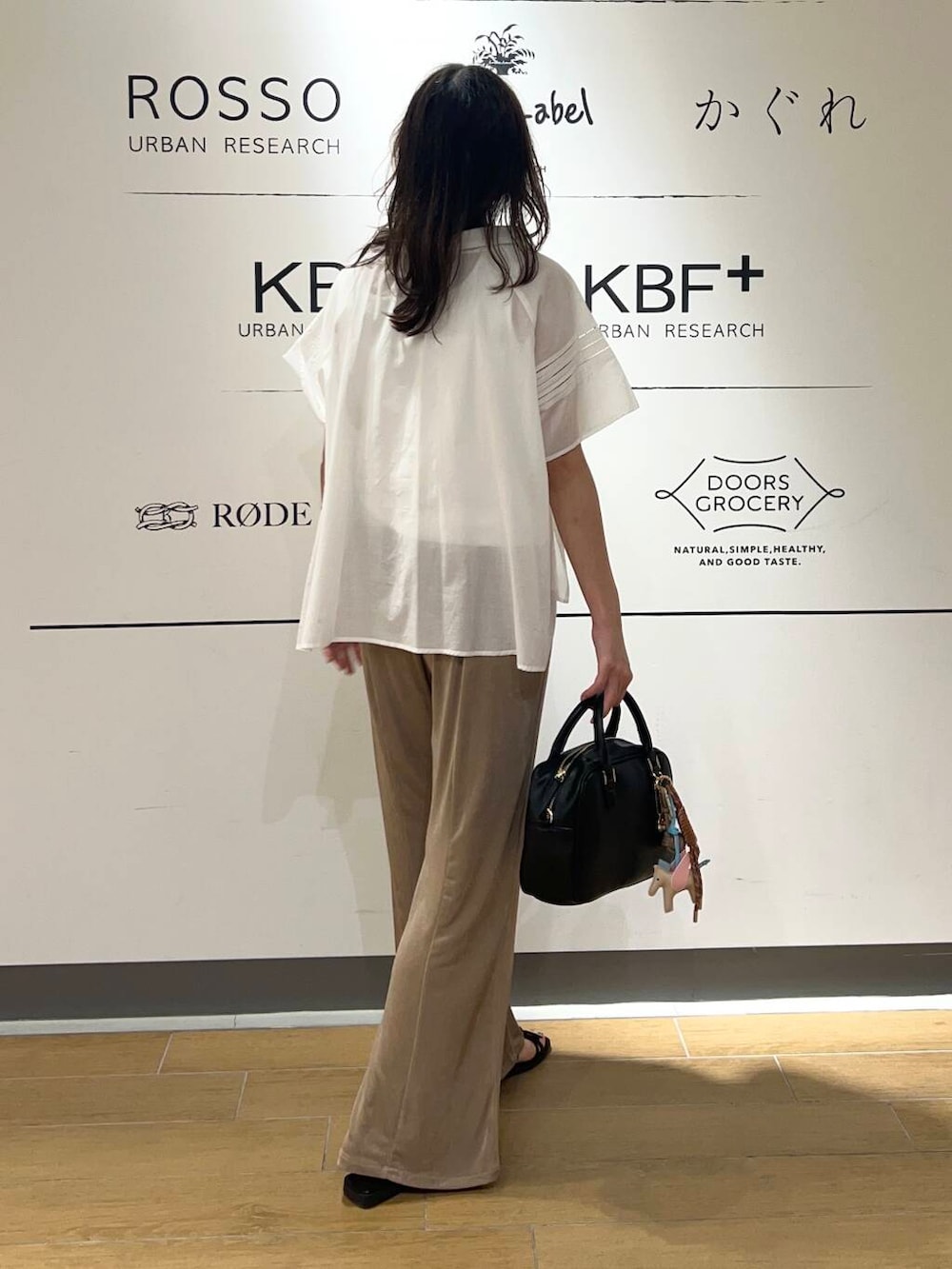 ホワイト系のタンクトップ、ブラック系のサンダル、ブラック系のボストンバッグを着用したレディースの夏コーディネートの3枚目の写真