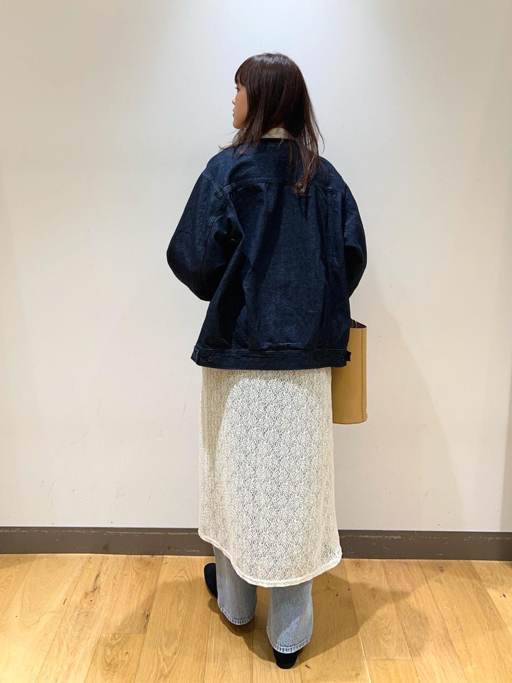 ブルー系のニット/セーター、ブルー系のデニムジャケット、ホワイト系のスカートを着用したレディースの冬コーディネートの4枚目の写真