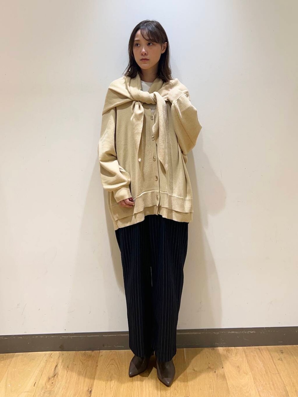 ホワイト系のニット/セーター、イエロー系のニット/セーター、ブラウン系のブーツを着用したレディースの冬コーディネートの2枚目の写真