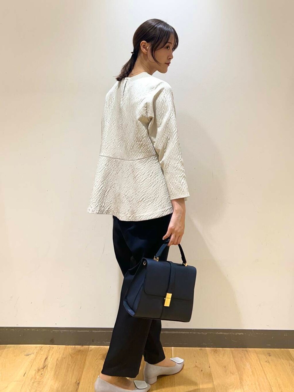 ブルー系のハンドバッグ、ブルー系のその他パンツ、ベージュ系のシャツ/ブラウスを着用したレディースの冬コーディネートの3枚目の写真