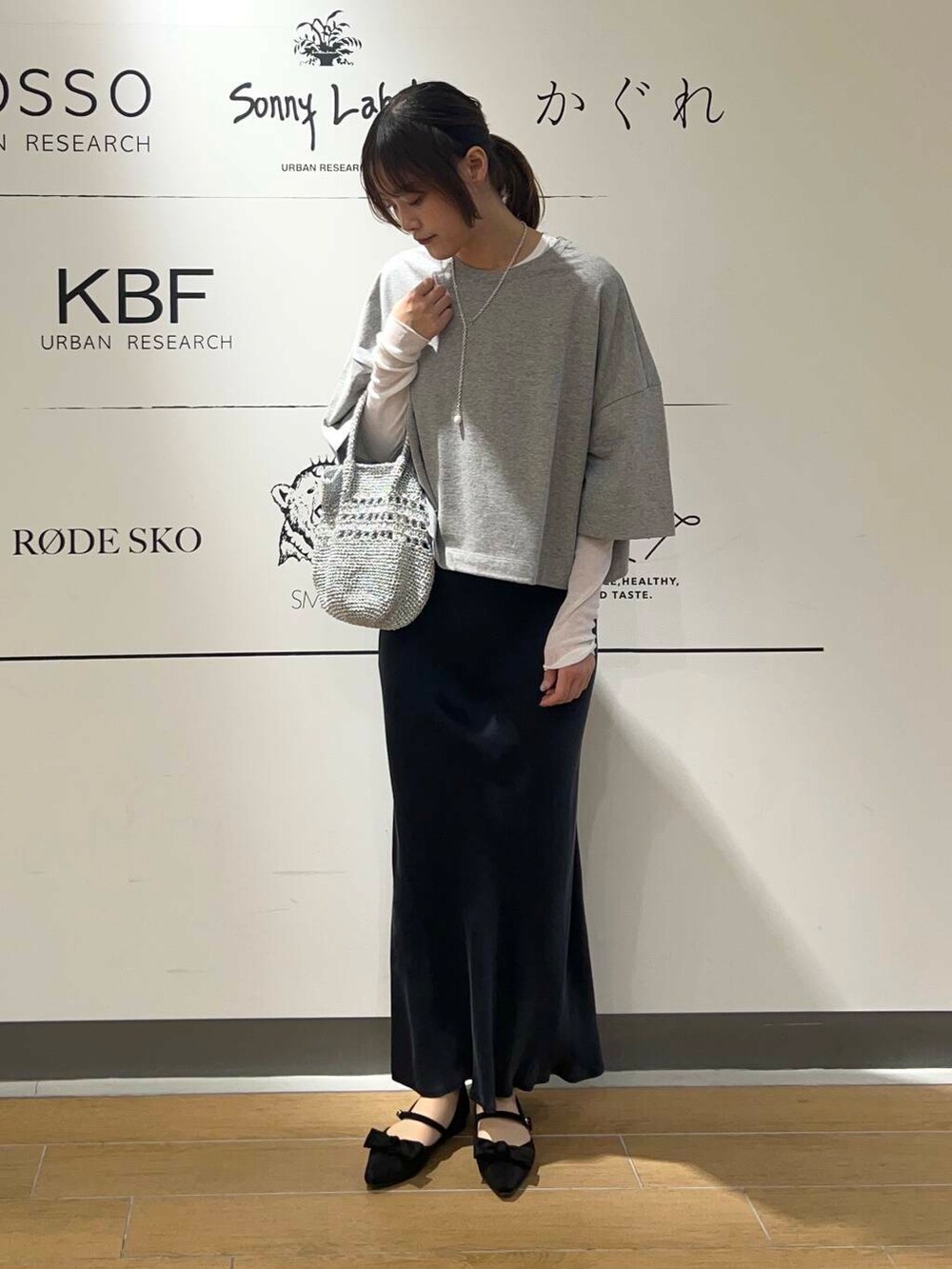 シルバー系のショルダーバッグ、ブルー系のスカート、ホワイト系のTシャツ/カットソーを着用したレディースの春コーディネートの2枚目の写真