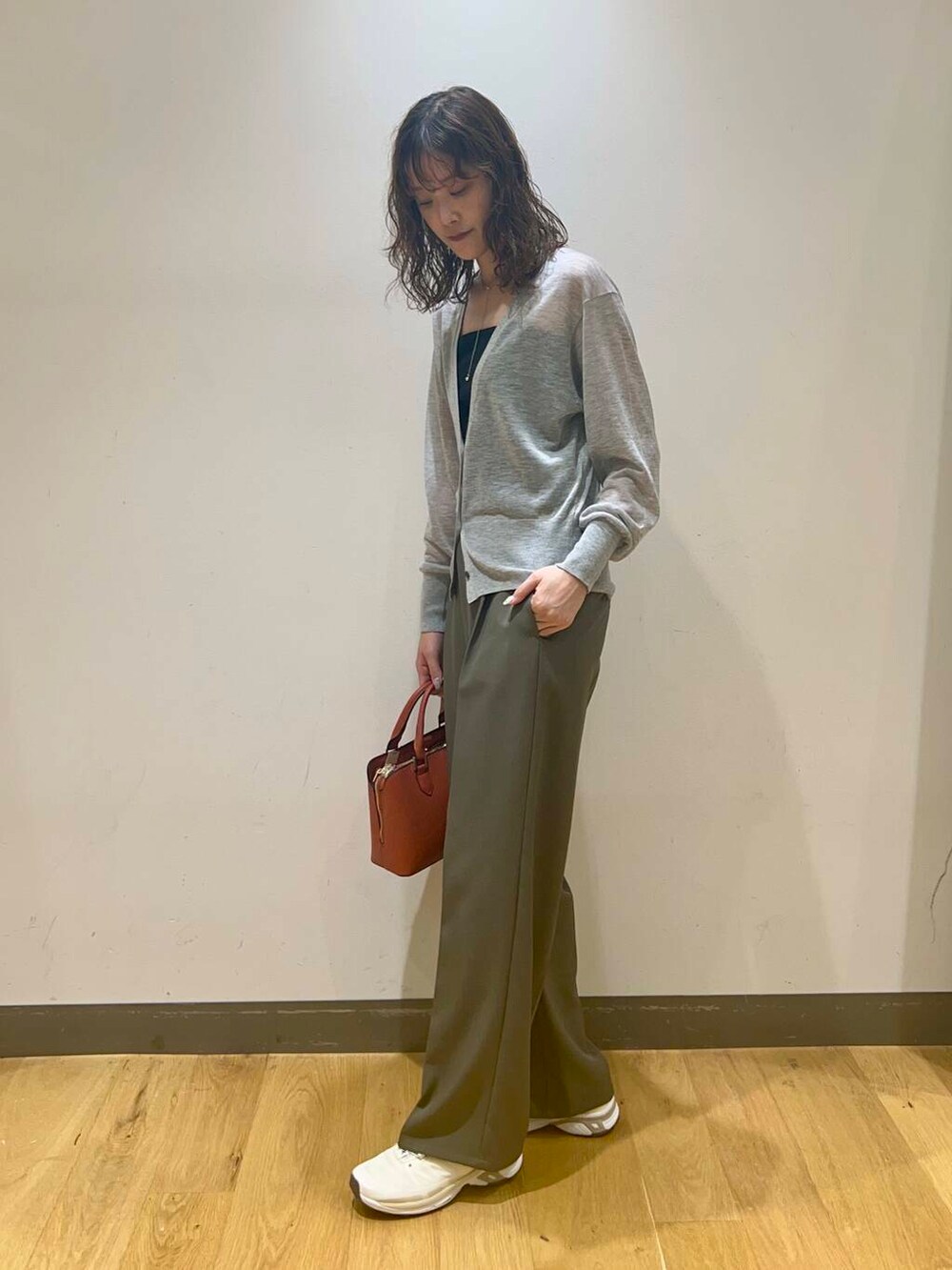 ブラック系のキャミソール、オレンジ系のハンドバッグ、グレー系のカーディガン/ボレロを着用したレディースの秋コーディネートの3枚目の写真