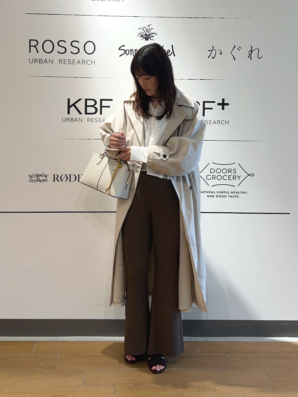 ベージュ系のトレンチコート、ホワイト系のシャツ/ブラウス、ブラウン系のその他パンツを着用したレディースの春コーディネートの2枚目の写真