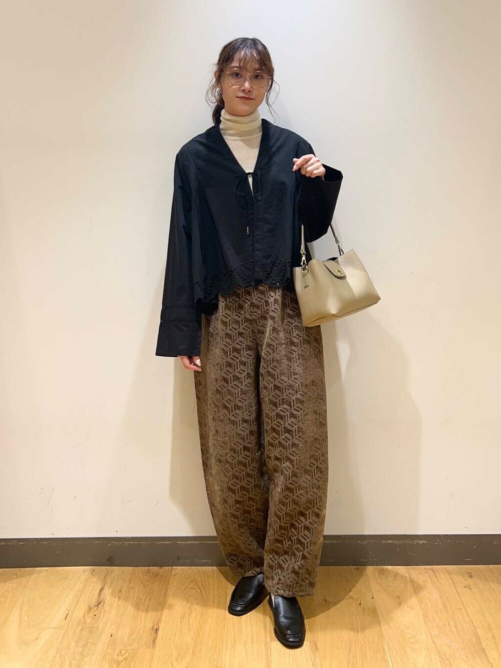 ブラック系のサンダル、ブラック系のカーディガン/ボレロ、ベージュ系のショルダーバッグを着用したレディースの秋コーディネートの2枚目の写真