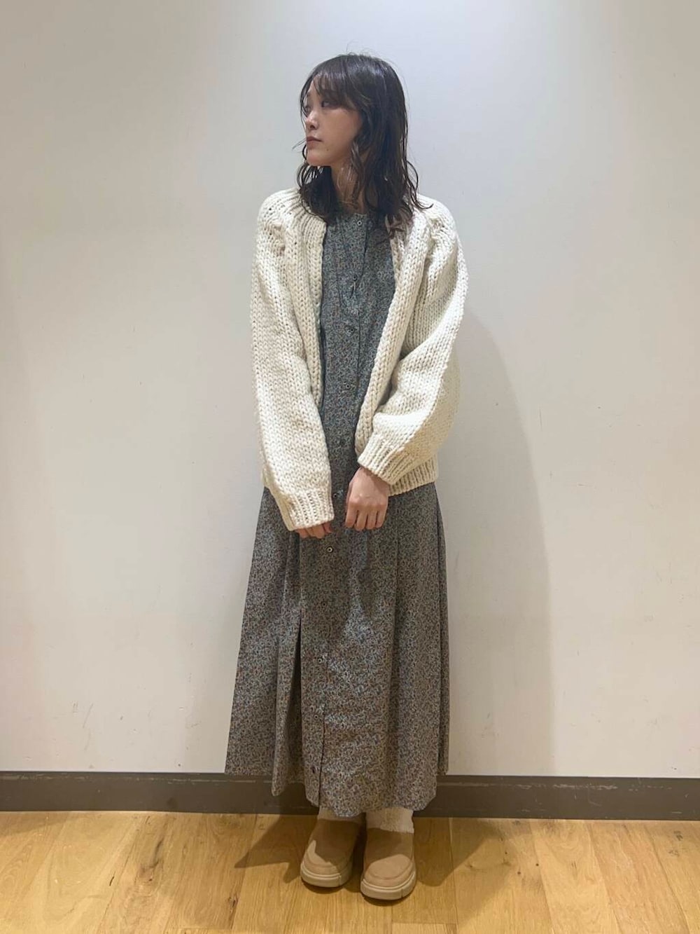 ホワイト系のニット/セーター、グレー系のワンピース、ベージュ系のブーツを着用したレディースの秋コーディネートの2枚目の写真