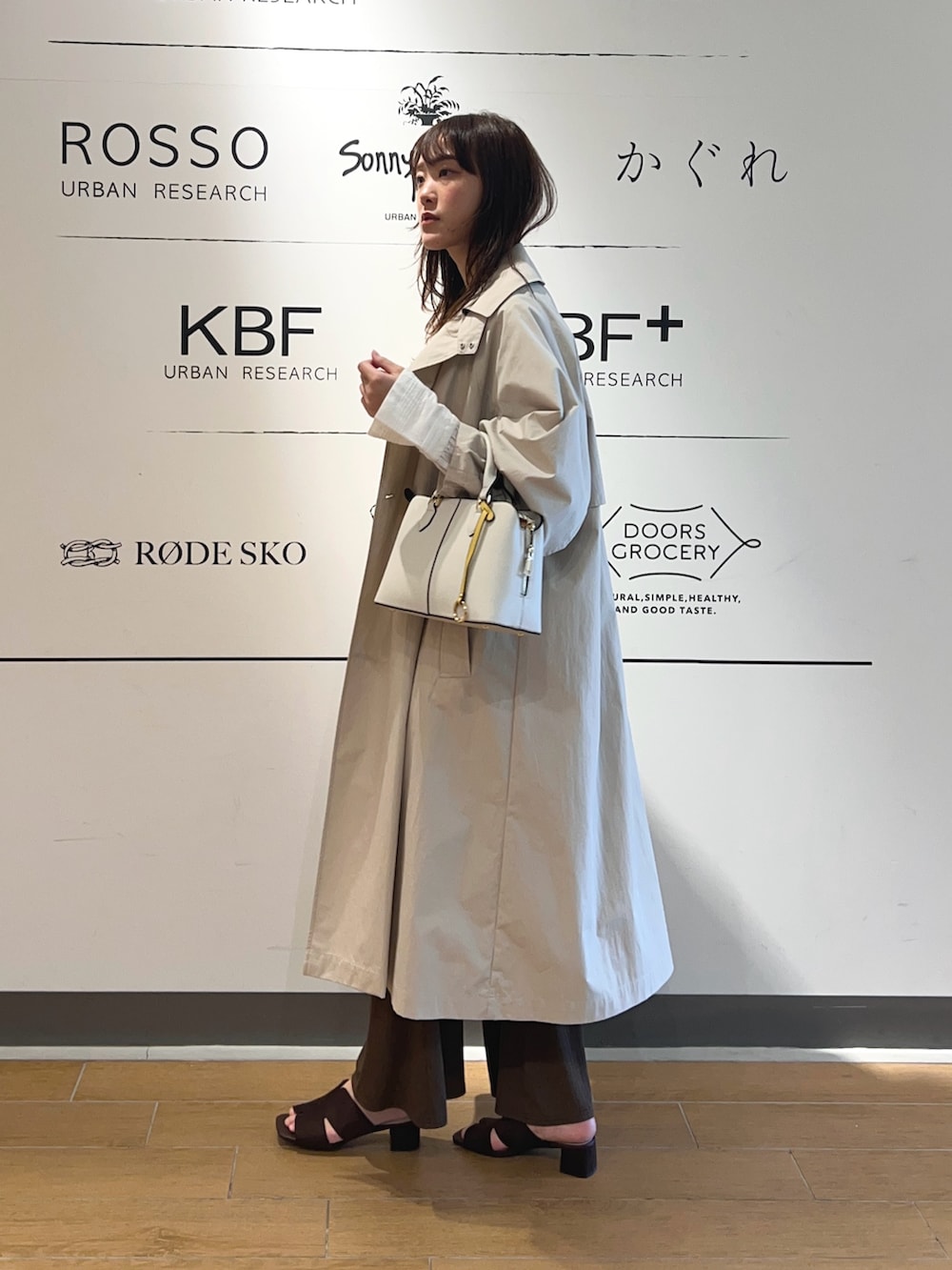 ベージュ系のトレンチコート、ホワイト系のシャツ/ブラウス、ブラウン系のその他パンツを着用したレディースの春コーディネートの3枚目の写真