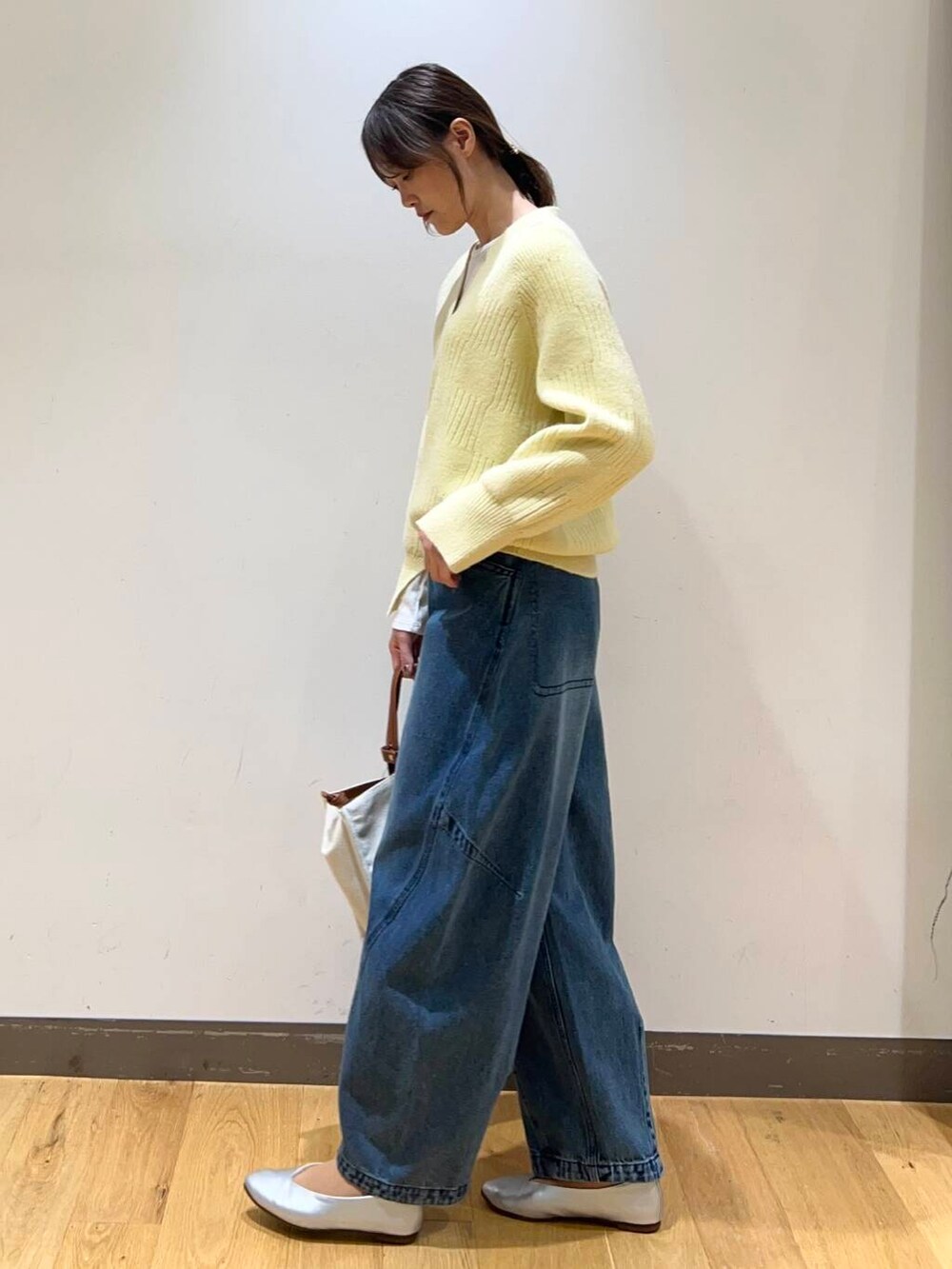 ホワイト系のTシャツ/カットソー、ベージュ系のトートバッグ、シルバー系のパンプスを着用したレディースの冬コーディネートの2枚目の写真