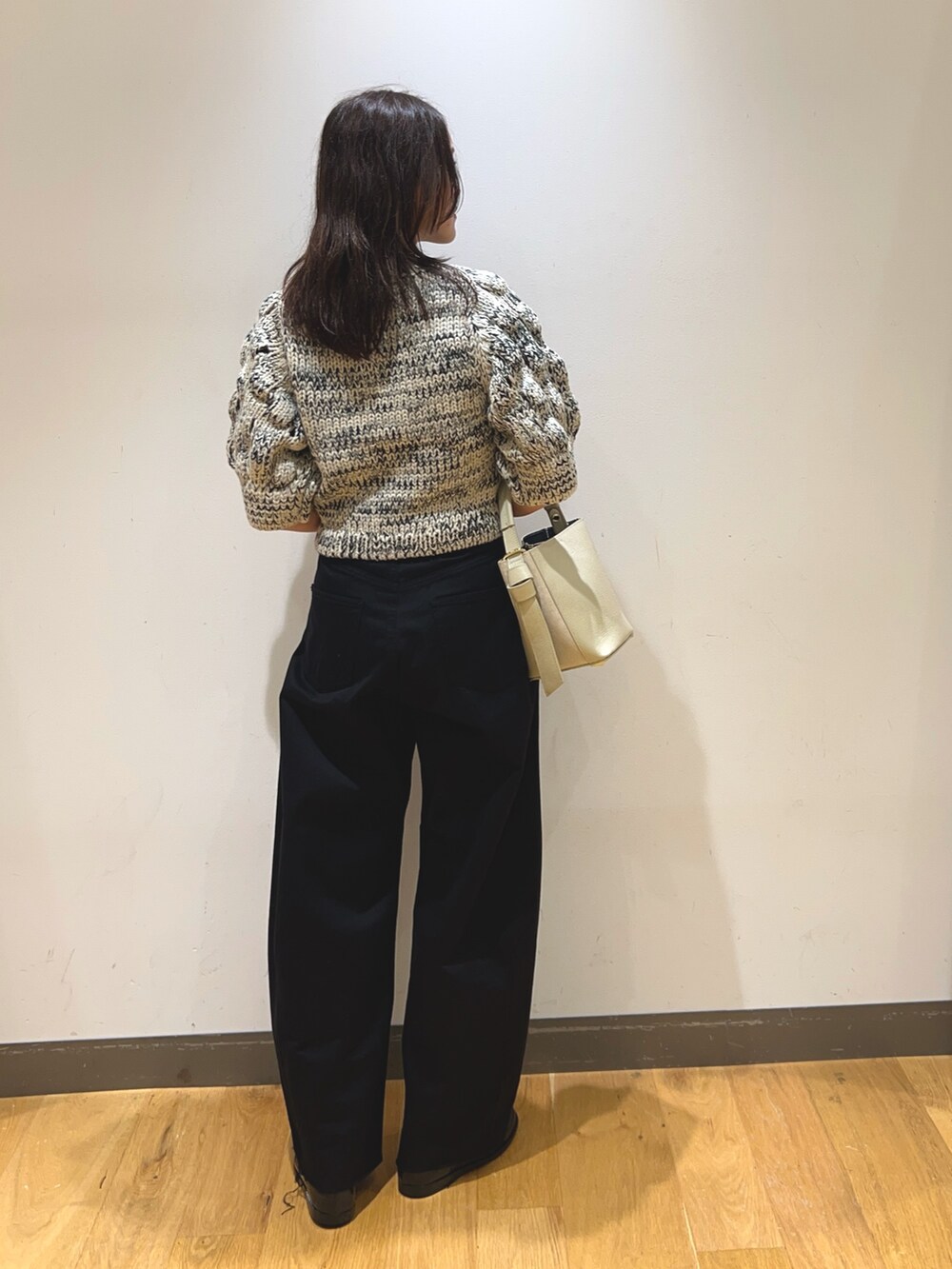 ホワイト系のニット/セーター、ブラック系のその他パンツ、ベージュ系のショルダーバッグを着用したレディースの秋コーディネートの3枚目の写真