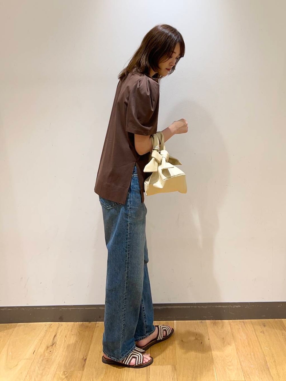 ブラウン系のサンダル、ブラウン系のTシャツ/カットソー、ゴールド系のネックレスを着用したレディースの春コーディネートの2枚目の写真