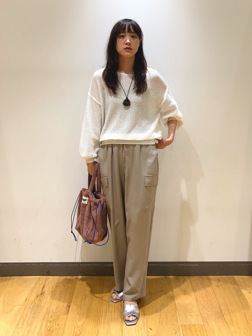 ホワイト系のニット/セーター、ベージュ系のその他パンツ、シルバー系のサンダルを着用したレディースの春コーディネートの3枚目の写真