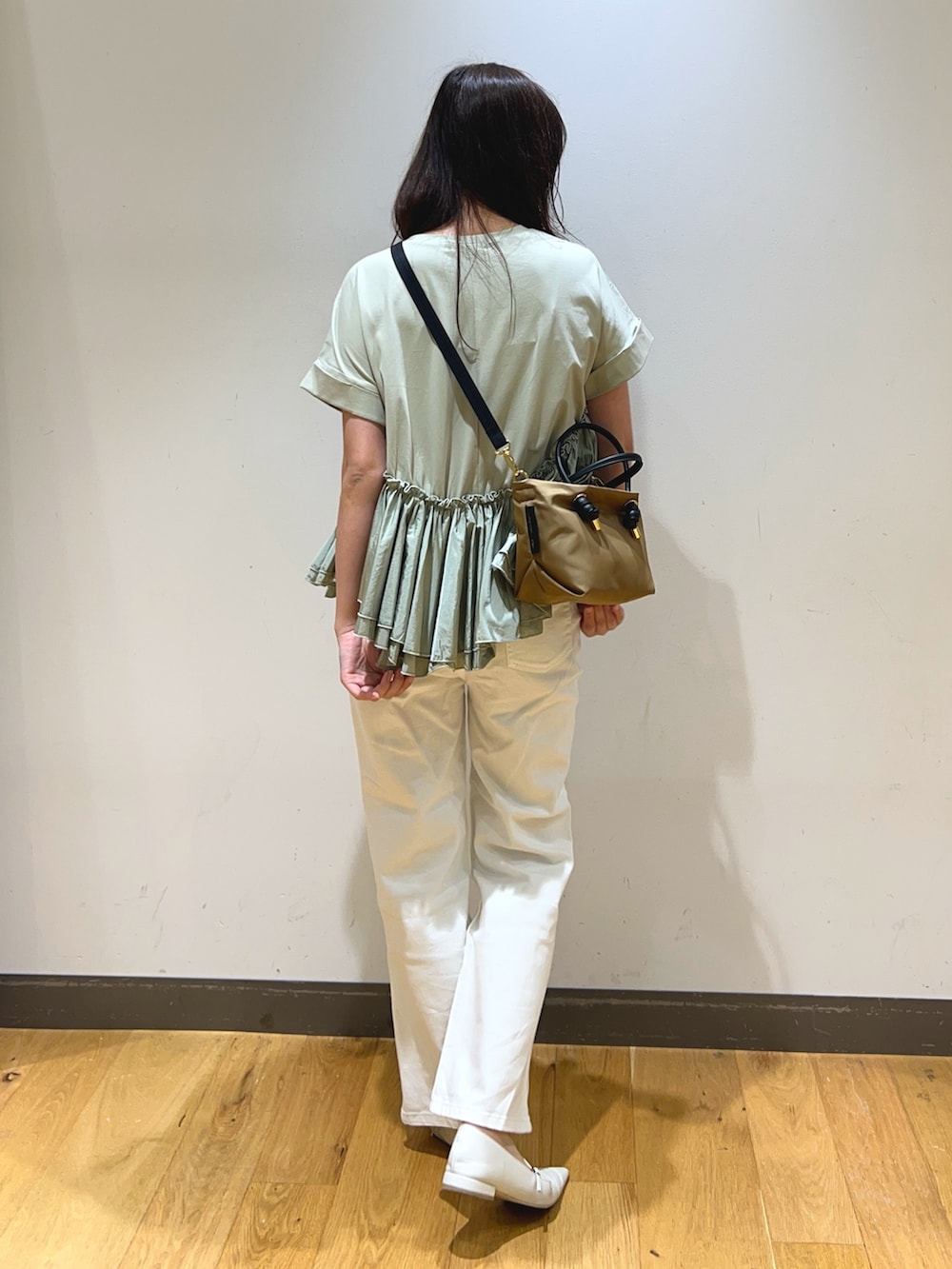 グリーン系のTシャツ/カットソー、ベージュ系のショルダーバッグ、ホワイト系のデニムパンツを着用したレディースの春コーディネートの4枚目の写真