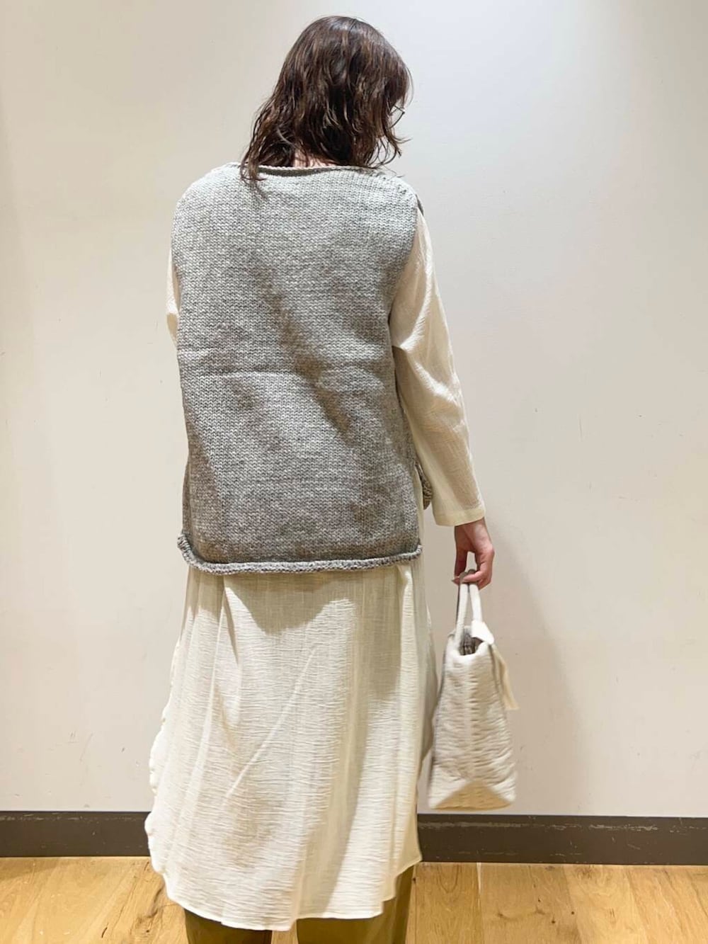 グレー系のニット/セーター、ホワイト系のトートバッグ、ブラック系のその他シューズを着用したレディースの秋コーディネートの4枚目の写真