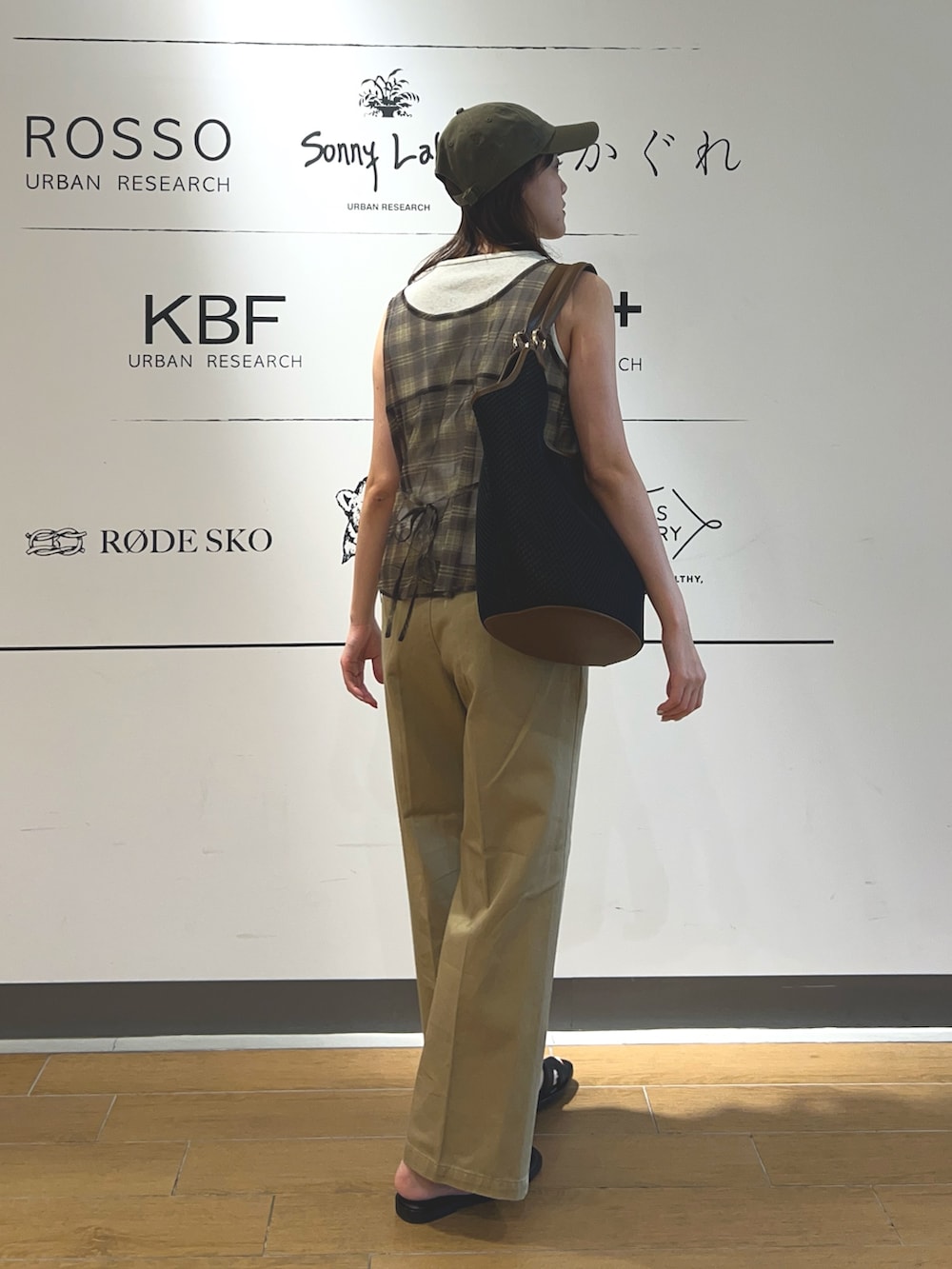 ベージュ系のその他パンツ、ブラック系のトートバッグ、ブラウン系のキャップを着用したレディースの夏コーディネートの3枚目の写真