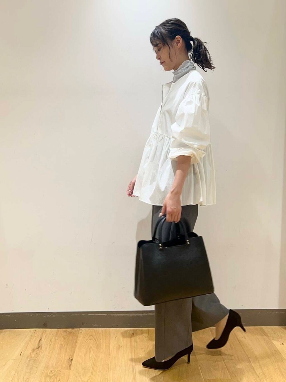 ブラック系のパンプス、ブルー系のTシャツ/カットソー、ホワイト系のシャツ/ブラウスを着用したレディースの秋コーディネートの3枚目の写真