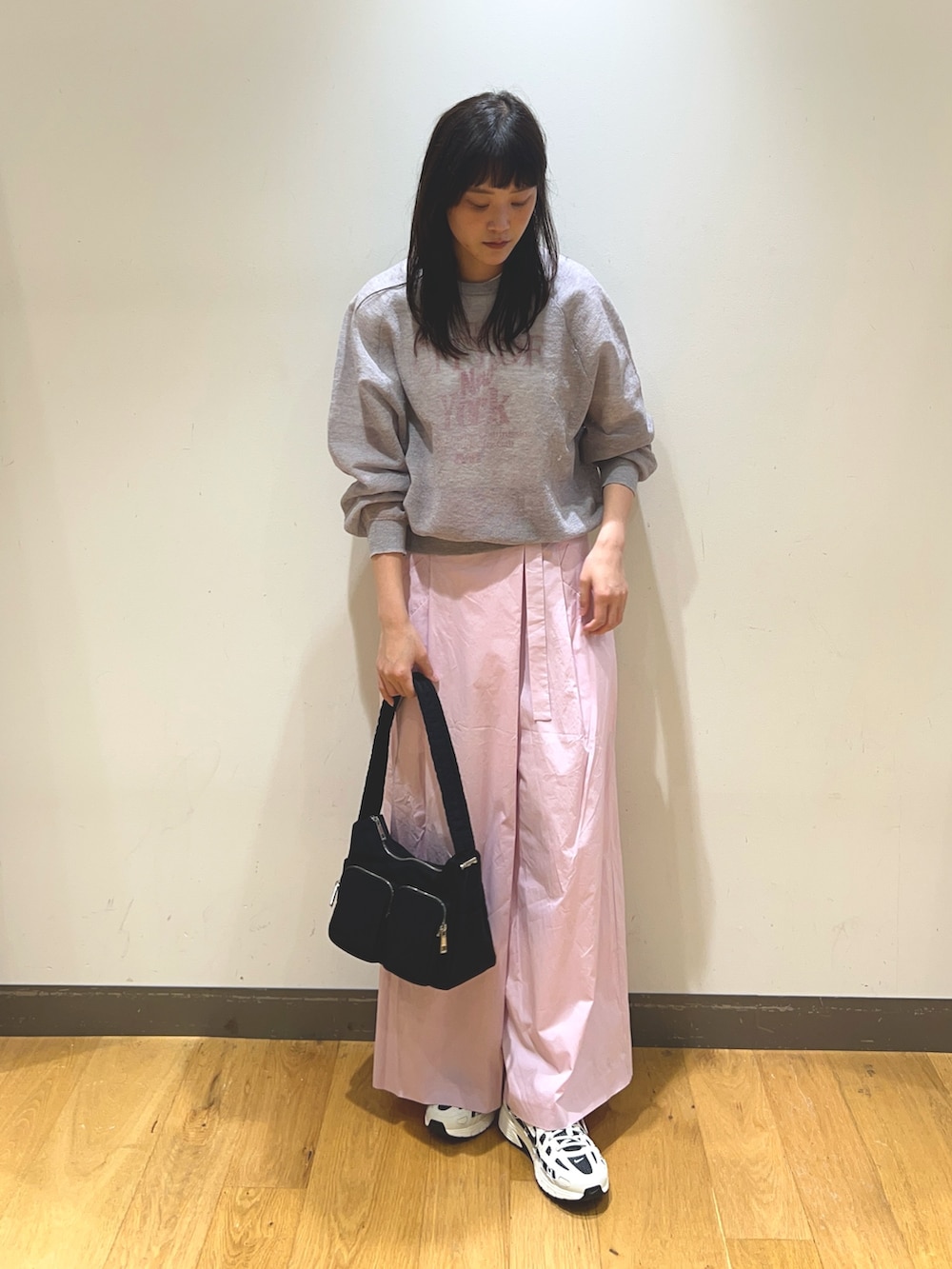 グレー系のニット/セーター、ピンク系のその他パンツ、ホワイト系のスニーカーを着用したレディースの春コーディネートの2枚目の写真