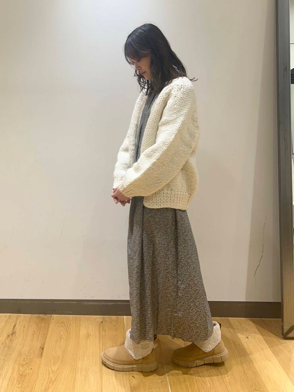 ホワイト系のニット/セーター、グレー系のワンピース、ベージュ系のブーツを着用したレディースの秋コーディネートの3枚目の写真