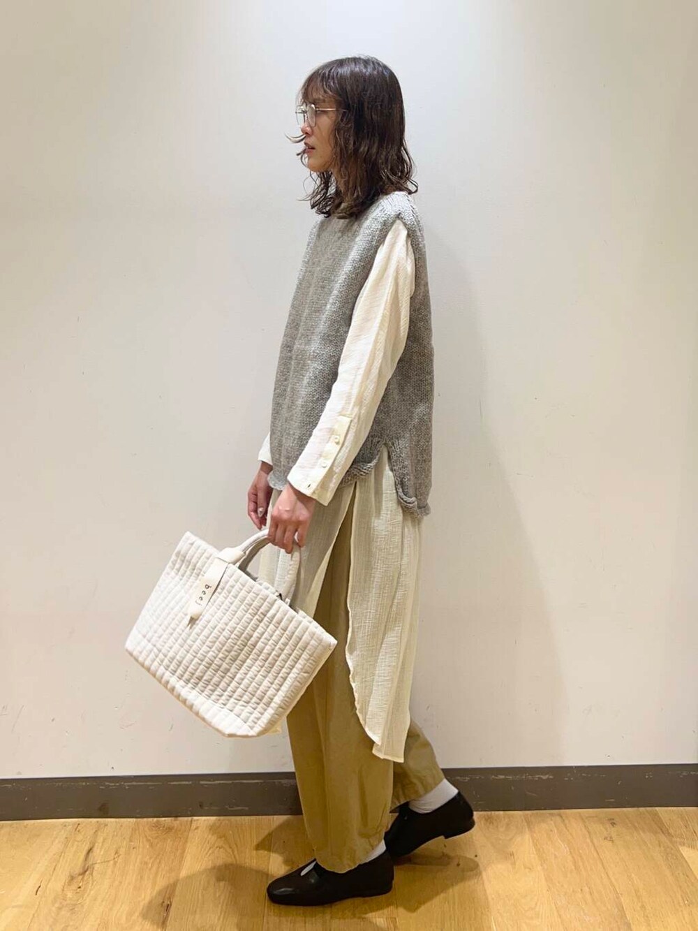 グレー系のニット/セーター、ホワイト系のトートバッグ、ブラック系のその他シューズを着用したレディースの秋コーディネートの2枚目の写真