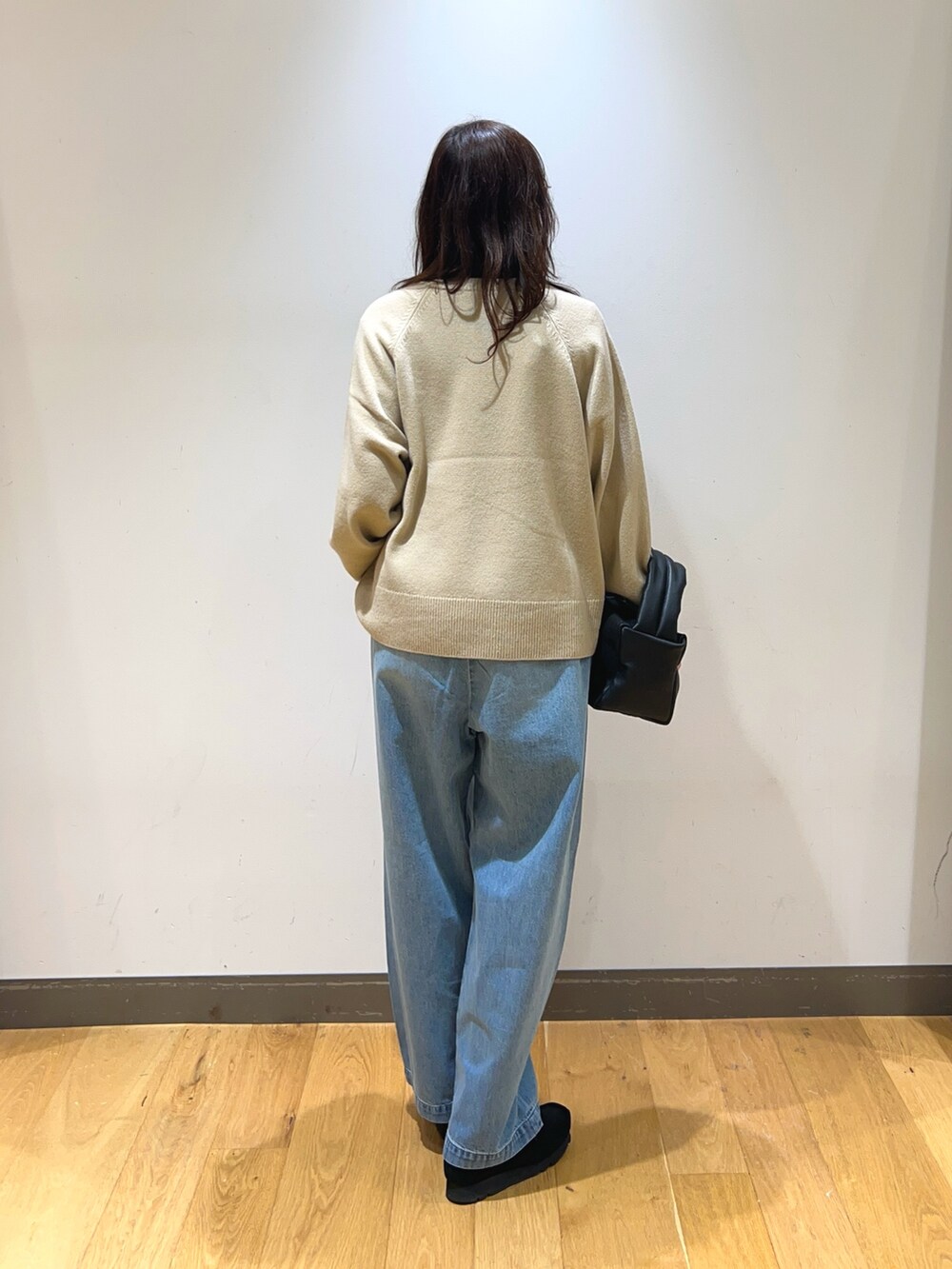 ブラック系のブーツ、ブラウン系のダウンベスト、ブラック系のハンドバッグを着用したレディースの冬コーディネートの4枚目の写真