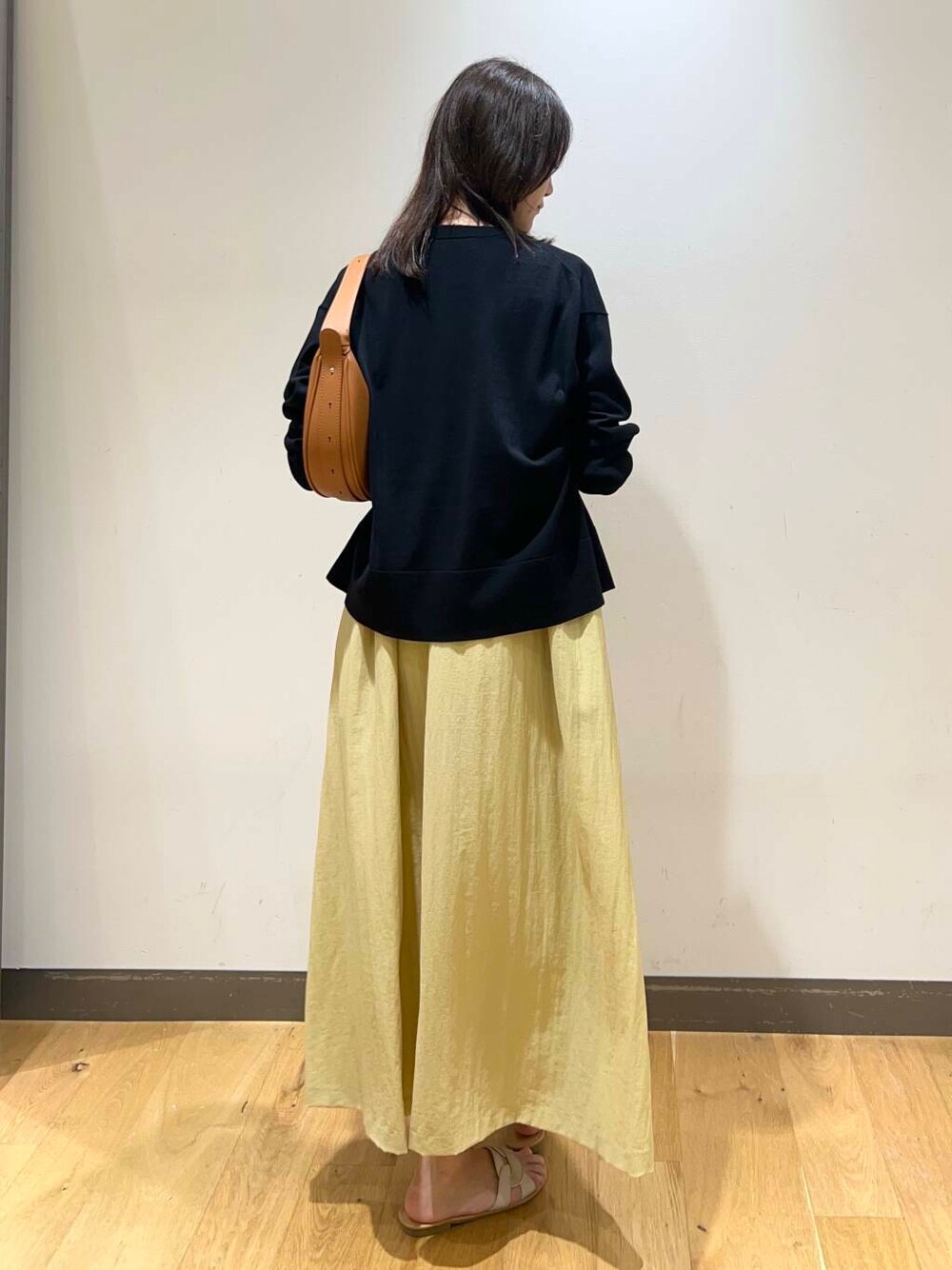 ホワイト系のサンダル、イエロー系のワンピース、ブラウン系のハンドバッグを着用したレディースの夏コーディネートの3枚目の写真