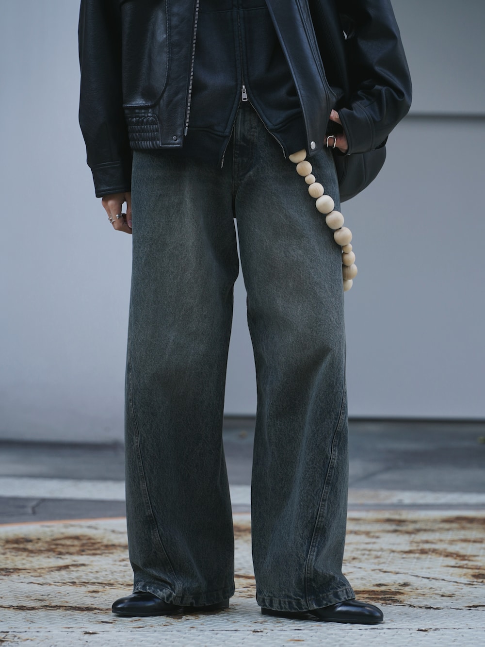 ブラック系のブルゾン、ブラック系のパーカー、ブルー系のデニムパンツを着用したメンズの冬コーディネートの4枚目の写真