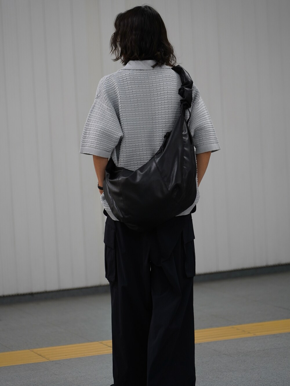 グレー系のポロシャツ、ブラック系のカーゴパンツ、ブラック系のサンダルを着用したメンズの冬コーディネートの4枚目の写真