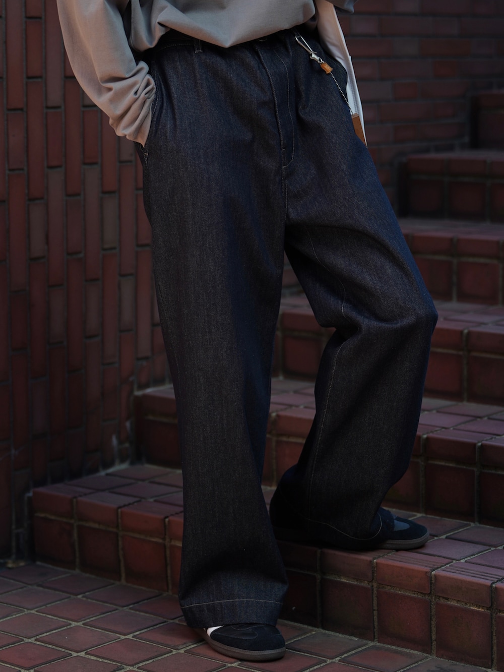 グレー系のTシャツ/カットソー、ブルー系のデニムパンツ、ブラック系のスニーカーを着用したメンズの夏コーディネートの4枚目の写真