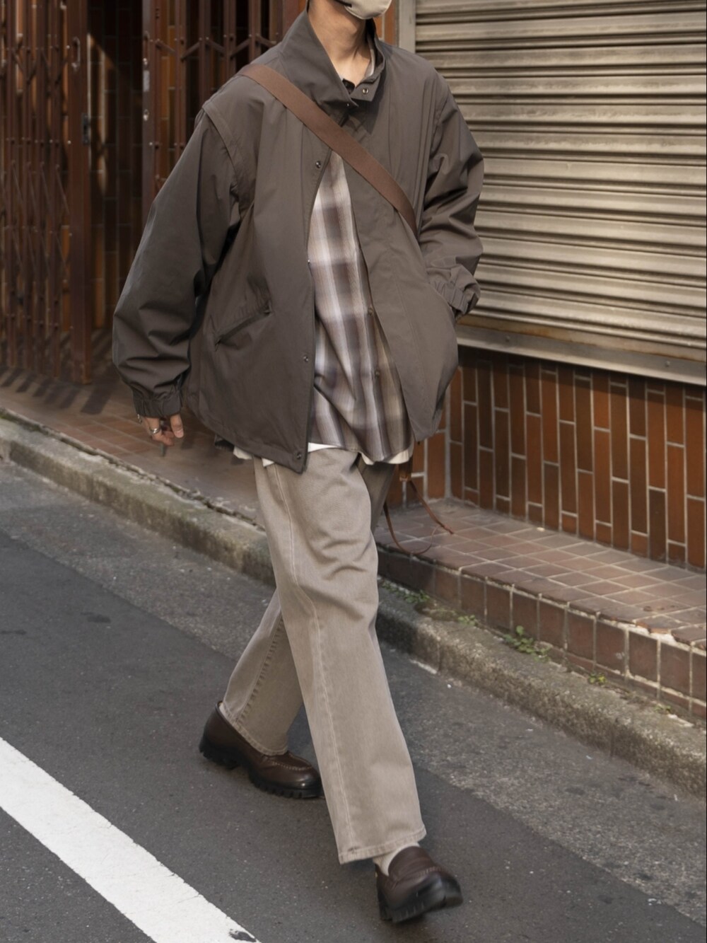 グレー系のブルゾン、ブラウン系のシャツ/ブラウス、ホワイト系のタンクトップを着用したメンズの春コーディネートの2枚目の写真