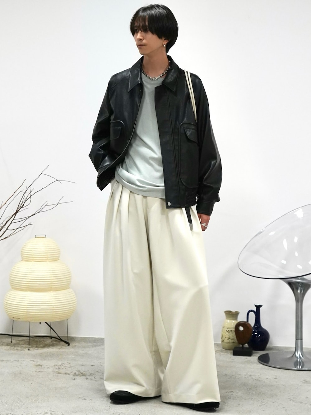 グリーン系のTシャツ/カットソー、ブラック系のブルゾン、ホワイト系のスラックスを着用したメンズの秋コーディネートの3枚目の写真