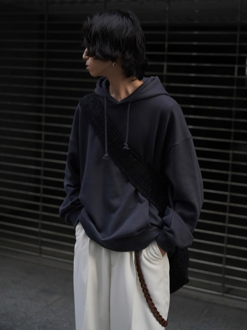 ブルー系のパーカー、ホワイト系のスラックス、ホワイト系のスニーカーを着用したメンズの秋コーディネートの3枚目の写真