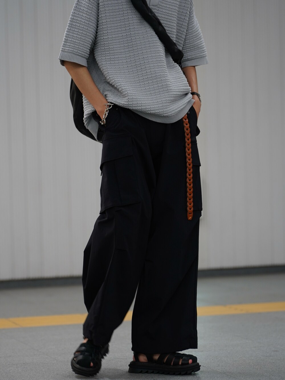 グレー系のポロシャツ、ブラック系のカーゴパンツ、ブラック系のサンダルを着用したメンズの冬コーディネートの5枚目の写真