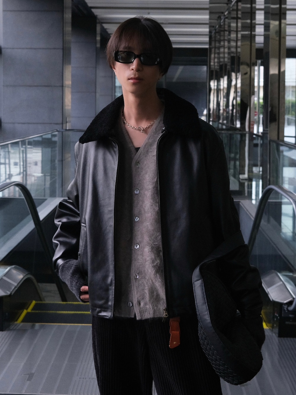 ブラック系のブルゾン、ブラック系のショルダーバッグ、ブラック系のブーツを着用したメンズの冬コーディネートの2枚目の写真