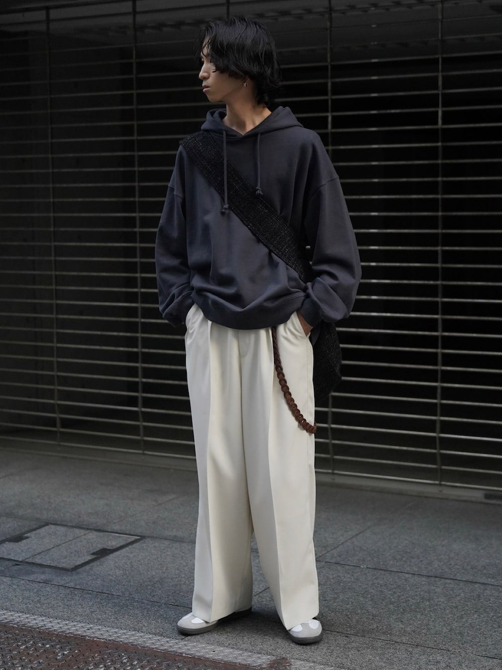 ブルー系のパーカー、ホワイト系のスラックス、ホワイト系のスニーカーを着用したメンズの秋コーディネートの2枚目の写真