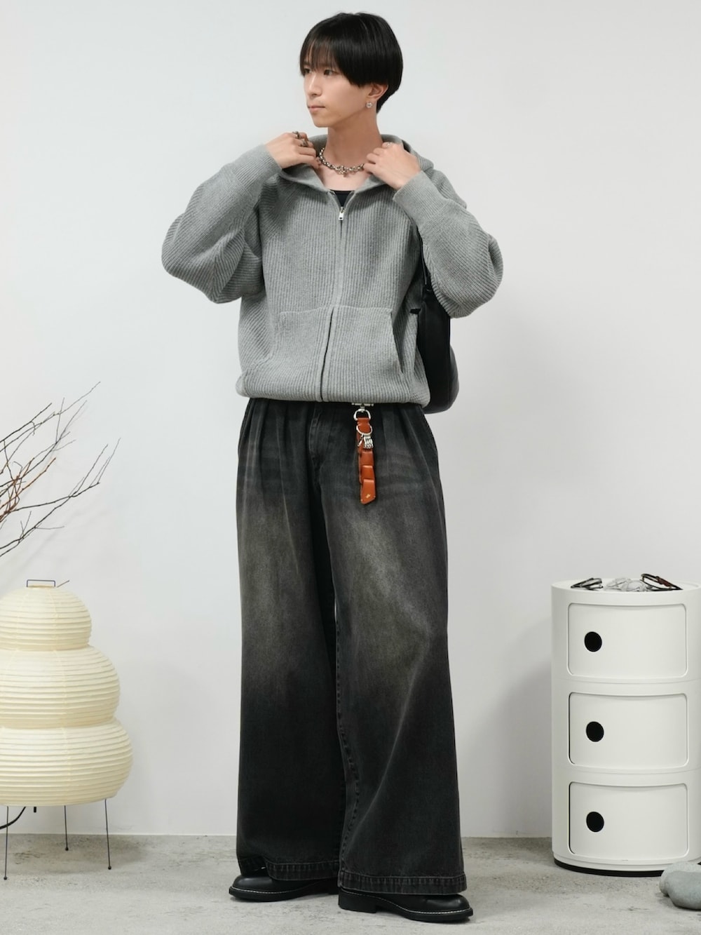 ブラック系のタンクトップ、グレー系のニット/セーター、ブラック系のデニムパンツを着用したメンズの秋コーディネートの2枚目の写真