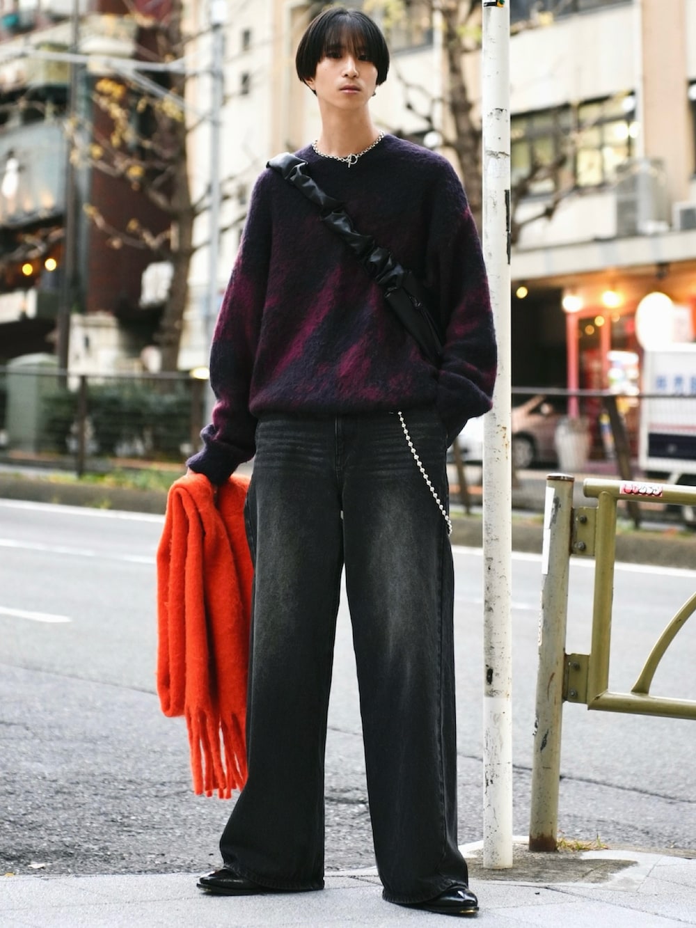 レッド系のニット/セーター、ブラック系のデニムパンツ、ブラック系のブーツを着用したメンズの冬コーディネートの3枚目の写真
