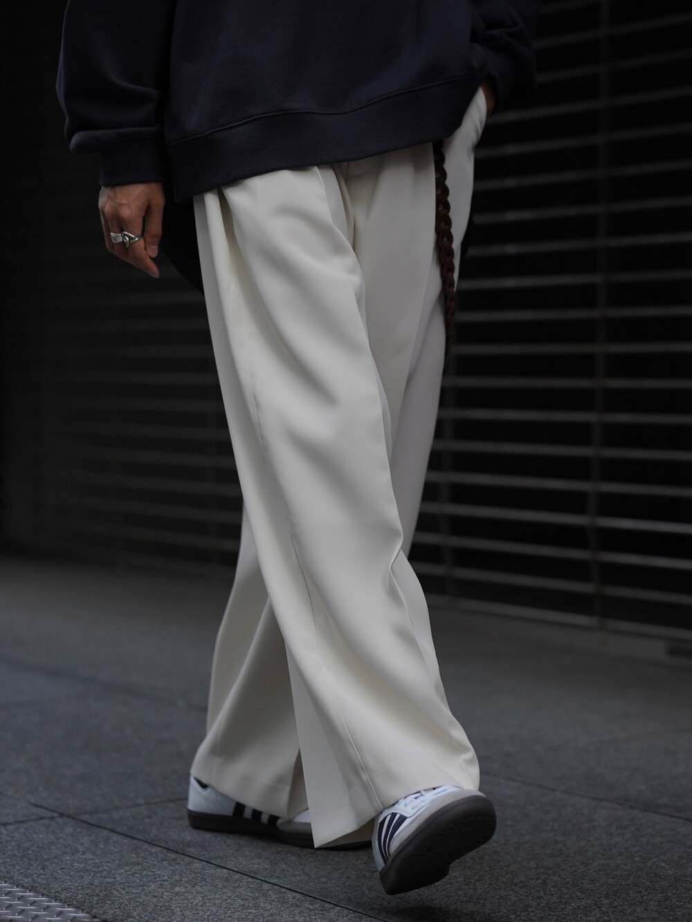 ブルー系のパーカー、ホワイト系のスラックス、ホワイト系のスニーカーを着用したメンズの秋コーディネートの5枚目の写真