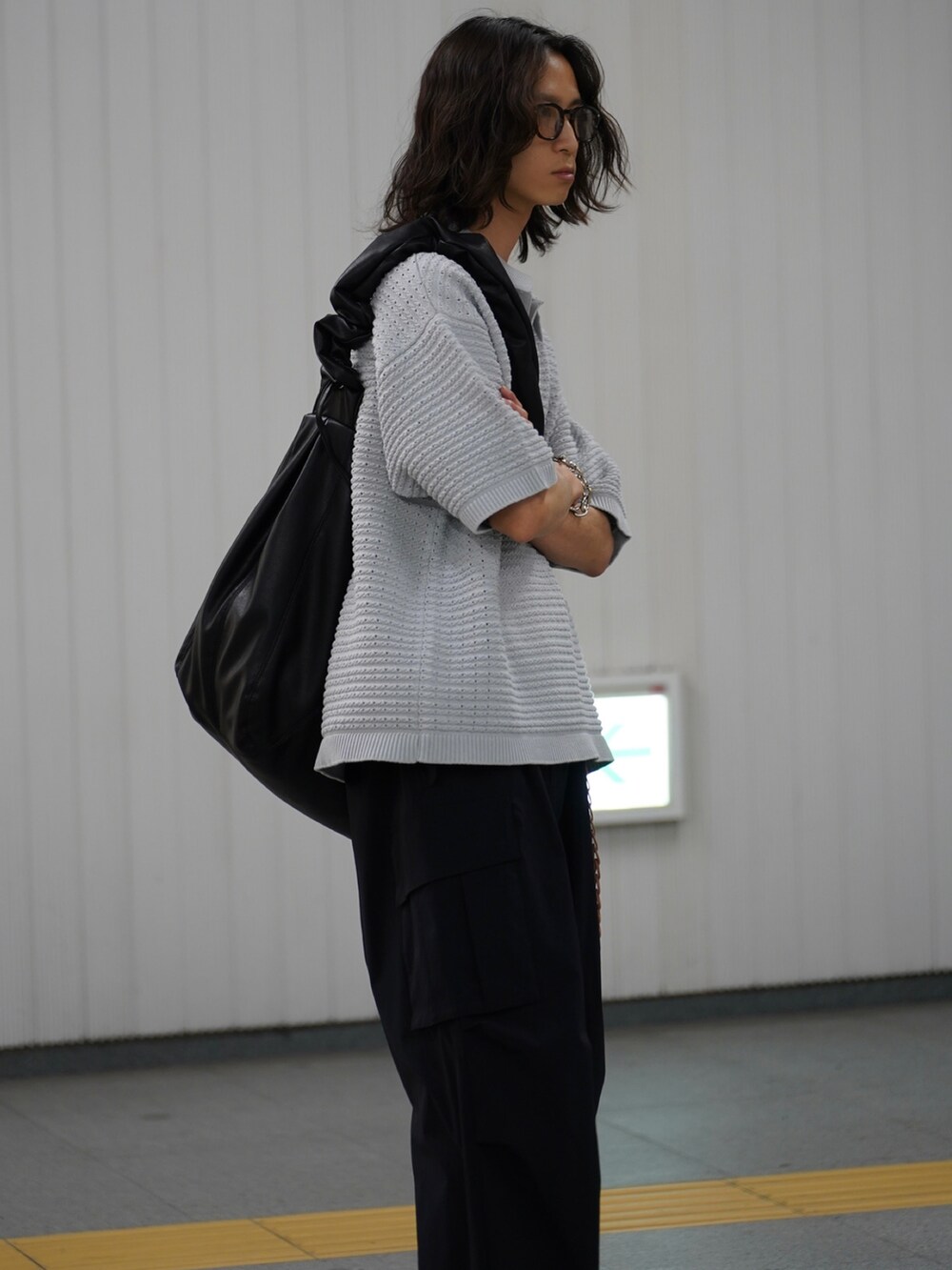 グレー系のポロシャツ、ブラック系のカーゴパンツ、ブラック系のサンダルを着用したメンズの冬コーディネートの3枚目の写真